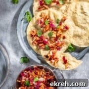 Indian onion chutney spread over poppadoms on a grey background.