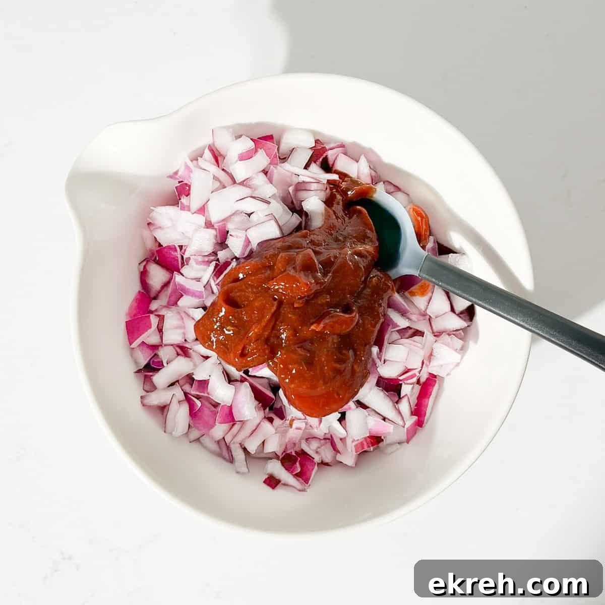Tangy Indian Onion Chutney Recipe for Poppadoms 10 Adding the sauce to the chopped onions in a large white bowl.