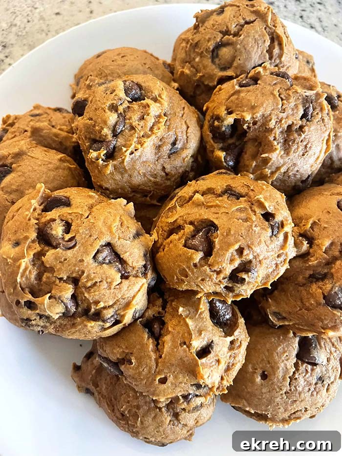 A plate full of chocolate chip pumpkin cookies stacked on each other.