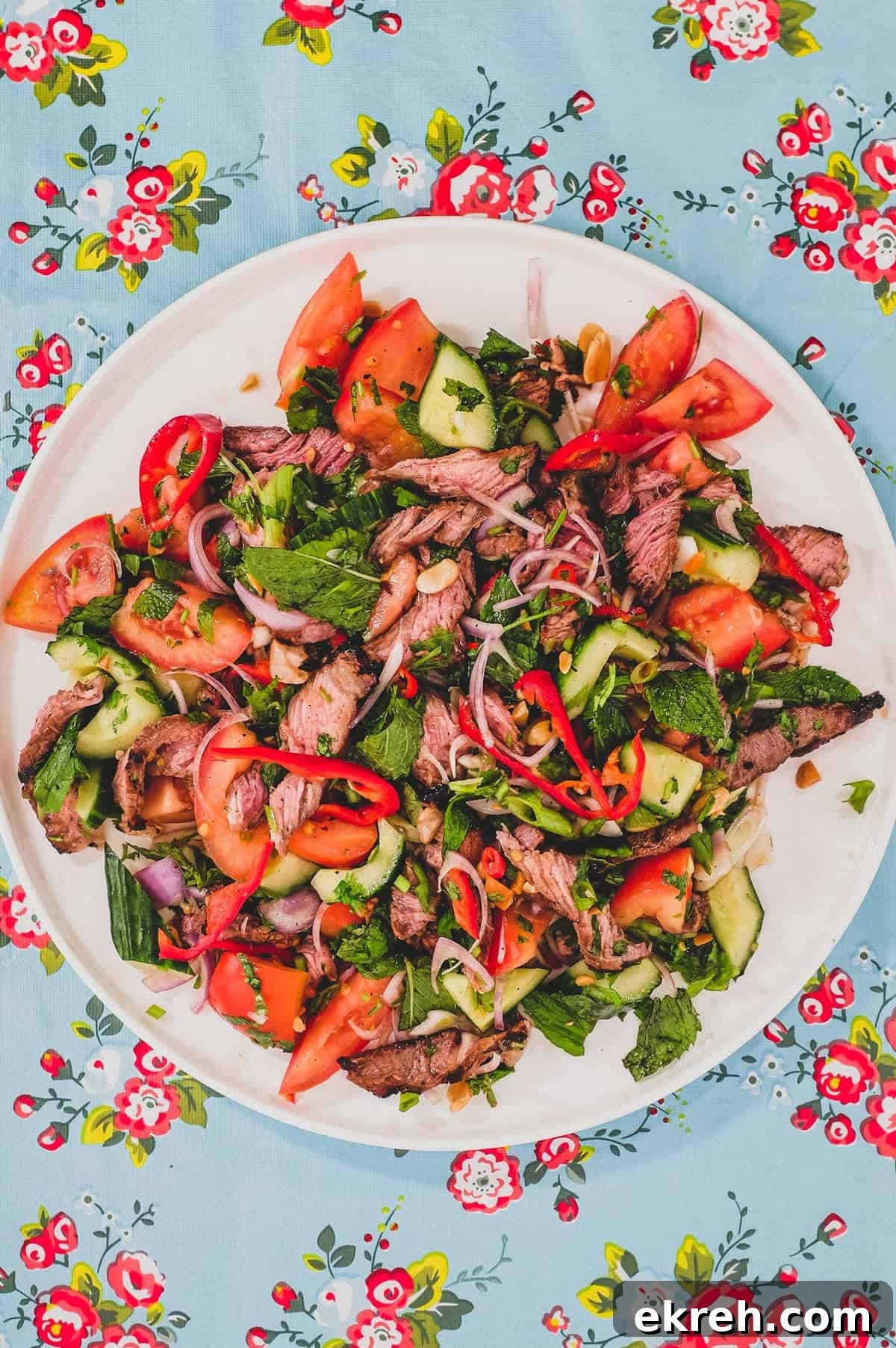 Thai Beef Salad (Yum Nua) | Cook Eat World Thinly sliced ribeye steak served with mint, cilantro, shallots and spring onion in a chilli dressing, topped with roasted peanuts.