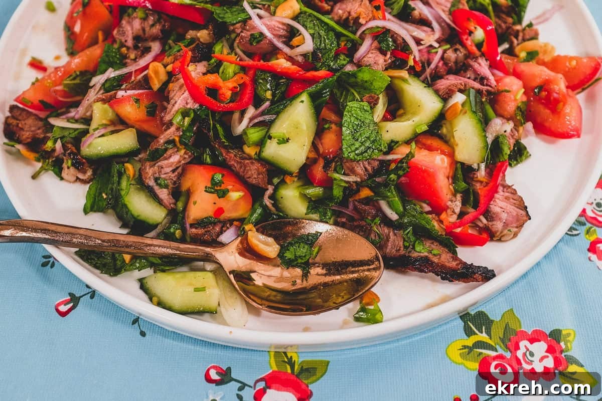 Thai Beef Salad (Yum Nua) | Cook Eat World Thai Beef Salad close-up with herbs and roasted peanuts.
