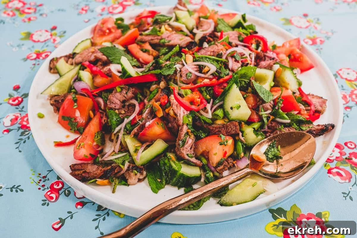 Grilled Thai Beef Salad (Yum Nua) with Lime and Chilies 2 Thai Beef Salad plated with herbs and peanuts.