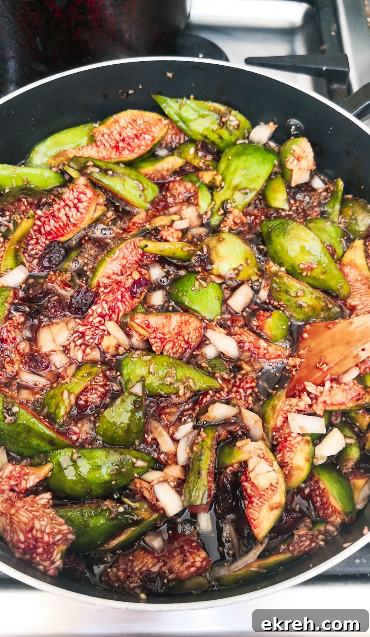 Fig chutney simmering on the stove top in a large pot.