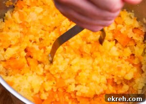 Mashing the carrot and swede with a masher