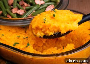 Carrot and Swede Mash scooped up on a large serving spoon