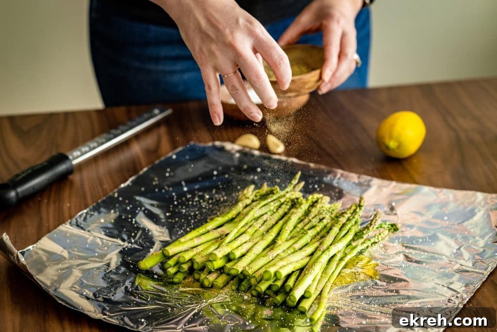 Salt and pepper being sprinkled on a pile of asparagus.