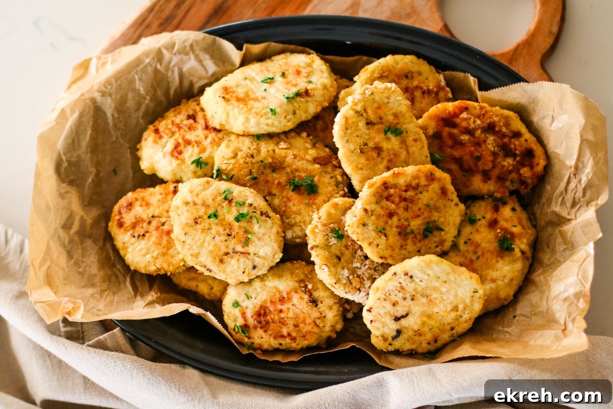 a platter piled high with golden-brown chicken kotleti, garnished with chopped parsley.