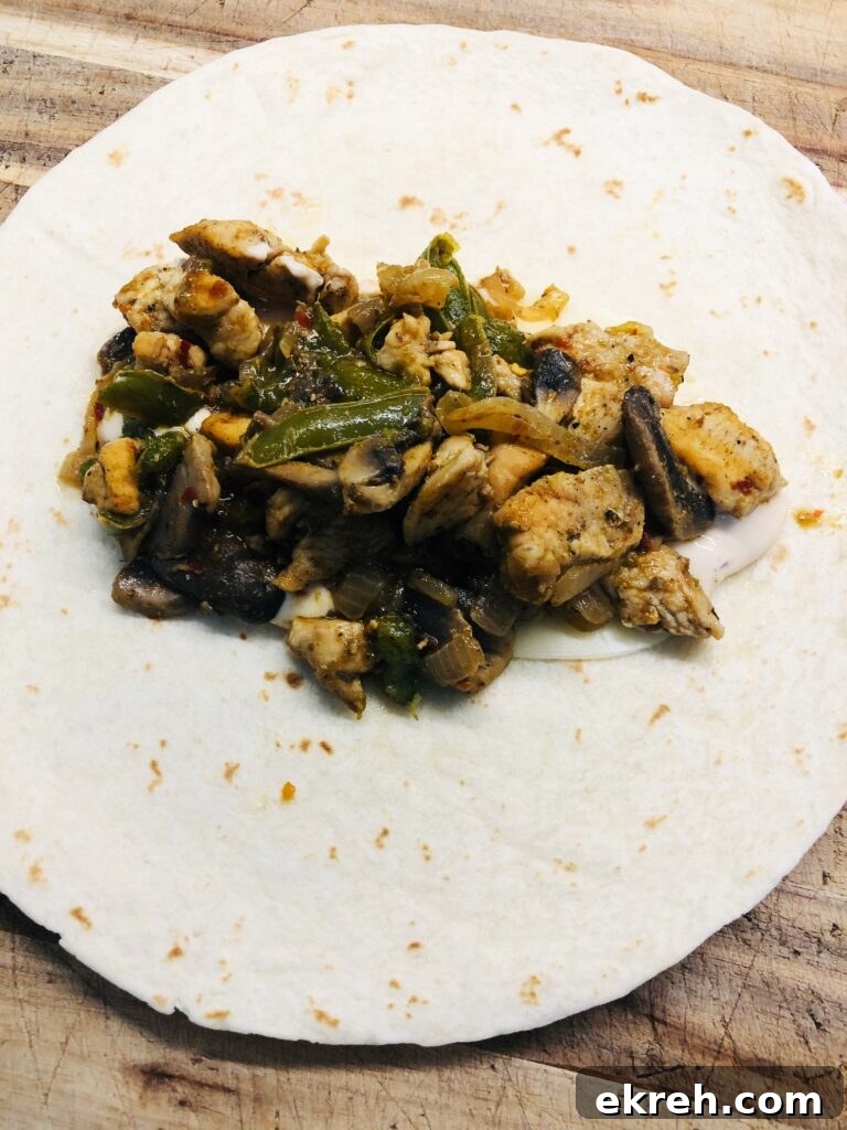 Air Fryer Philly Chicken Burritos Recipe 5 putting the chicken philly filling in the center of the tortilla