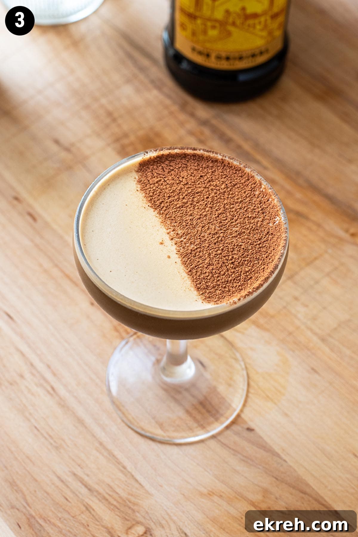 A chocolate espresso martini topped with a dusting of cocoa powder.