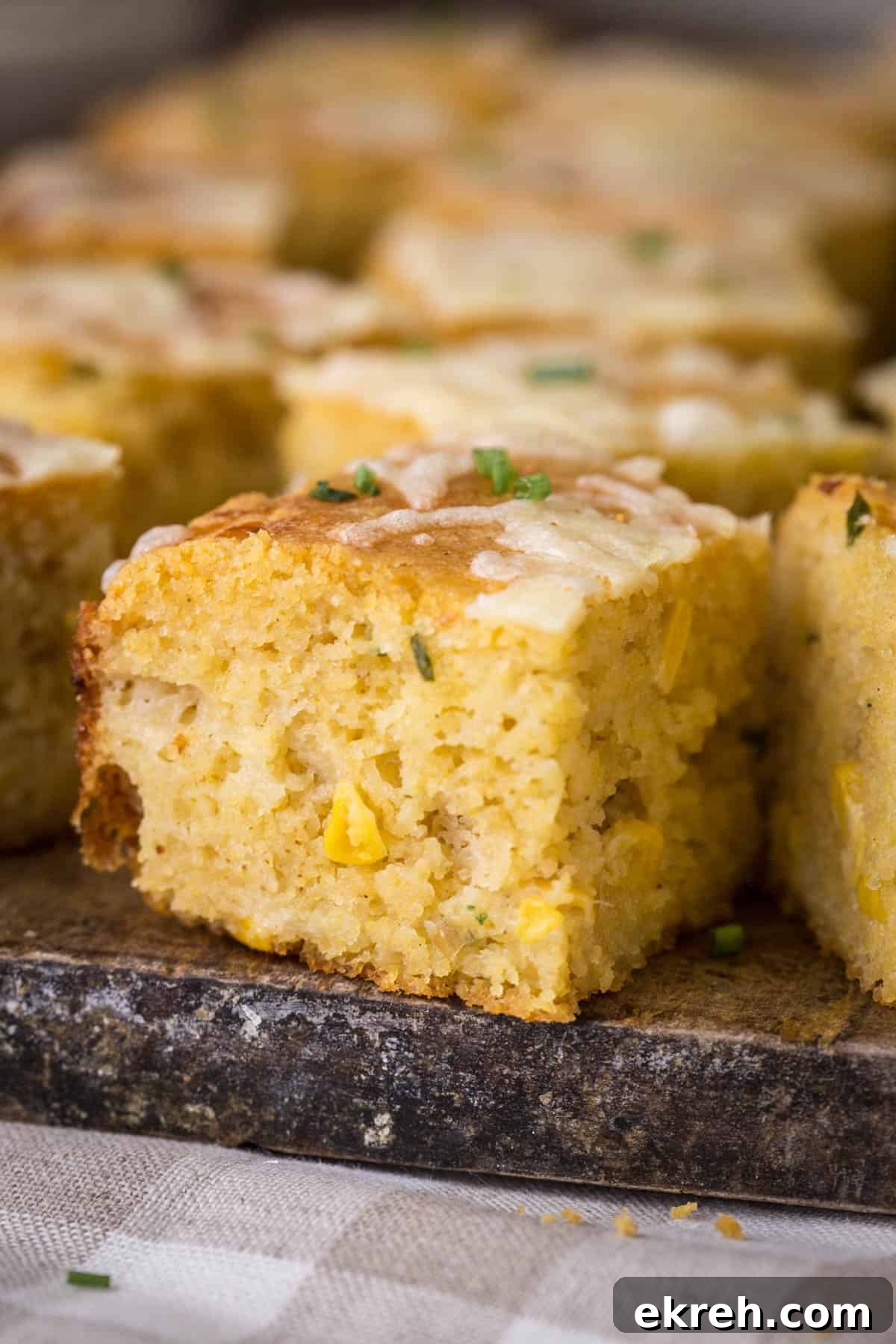 Cheddar and Chive Skillet Cornbread Recipe 3 Sliced gluten-free cheddar chive cornbread on a serving board.
