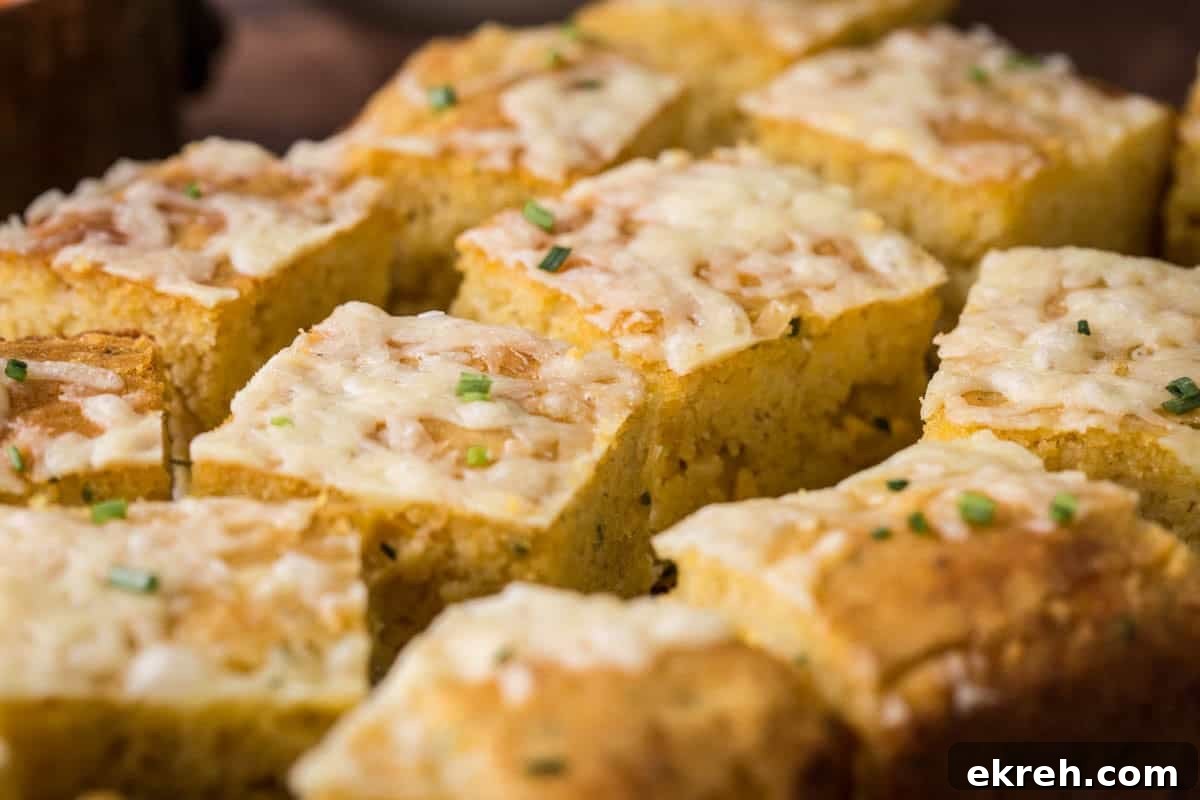 Cheddar and Chive Skillet Cornbread Recipe 6 Sliced gluten-free cheddar chive cornbread on a serving board.