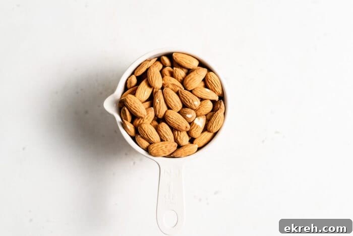 Raw almonds in a measuring cup.