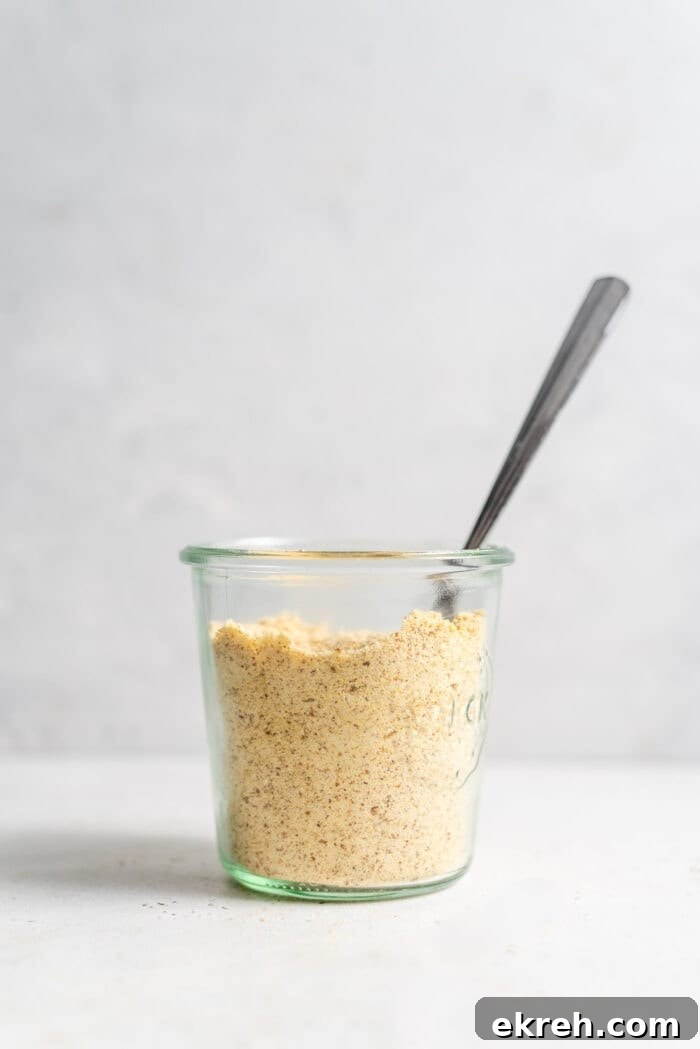 Vegan parmesan cheese in a jar with a spoon.