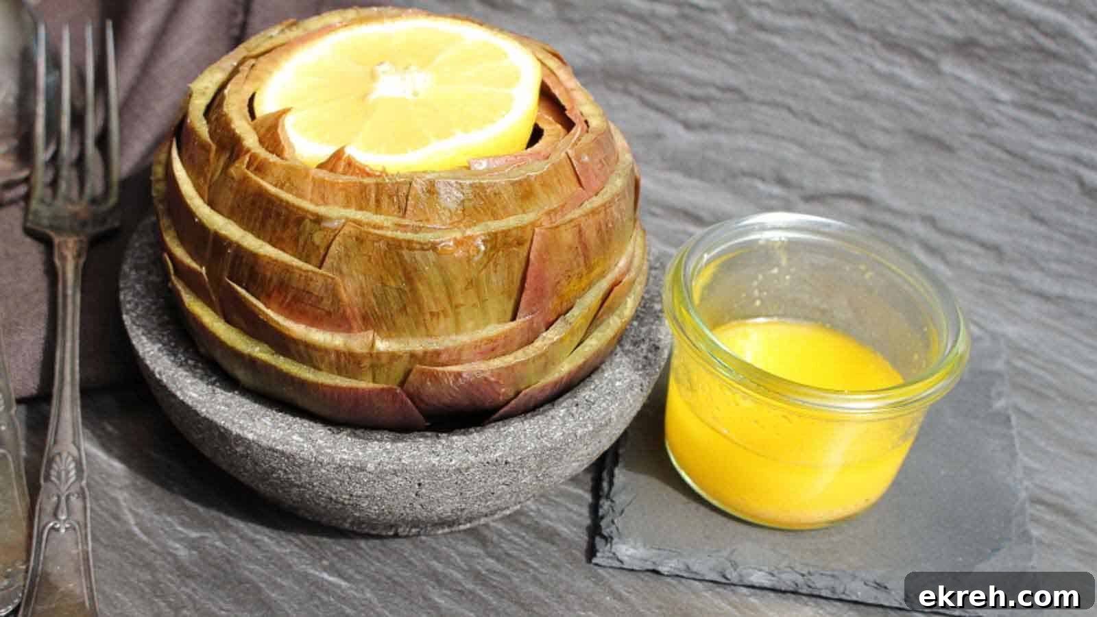 An artichoke in a bowl with lemon slices and a fork.