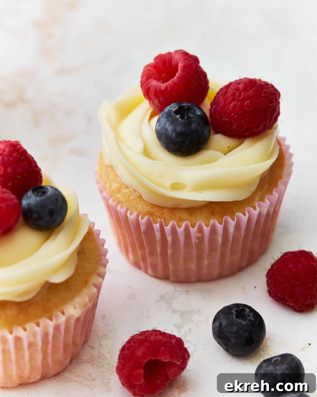 Frosted cupcakes topped with fresh berries.