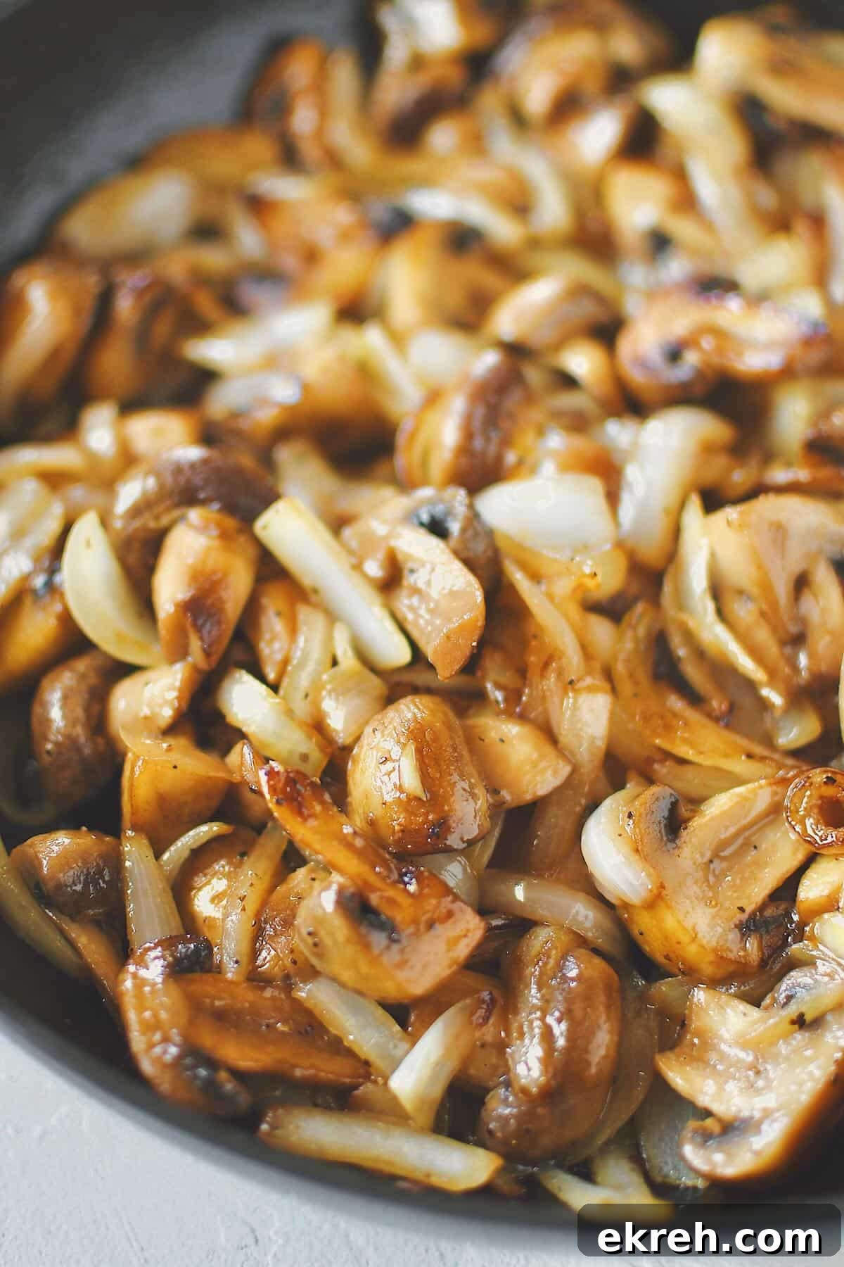 Garlic Butter Sauteed Mushrooms with Caramelized Onions 2 Sautéed Mushrooms and Onions, finished in the skillet, ready to be eaten.