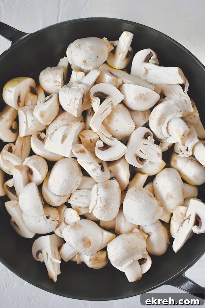 Garlic Butter Sauteed Mushrooms with Caramelized Onions 4 Mushroom added to a hot skillet with olive oil.
