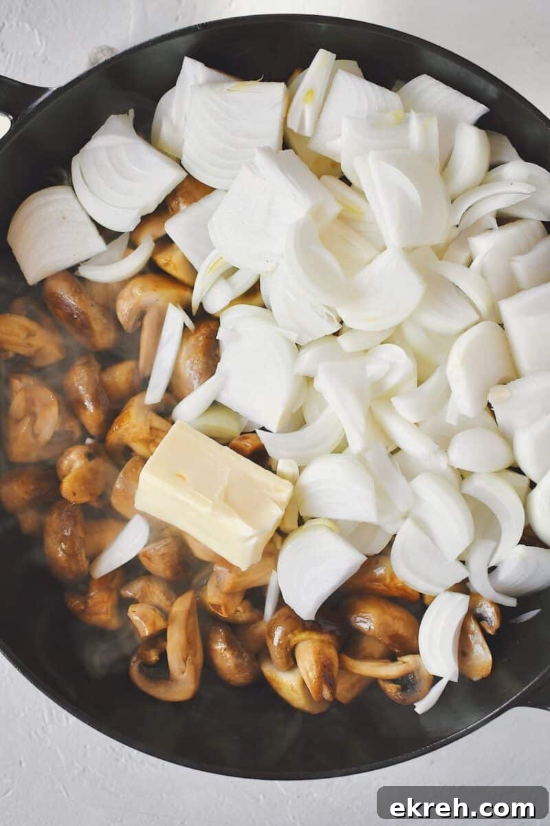 Garlic Butter Sauteed Mushrooms with Caramelized Onions 6 Adding the butter and onions to the steamed mushrooms after their liquid has evaporated.