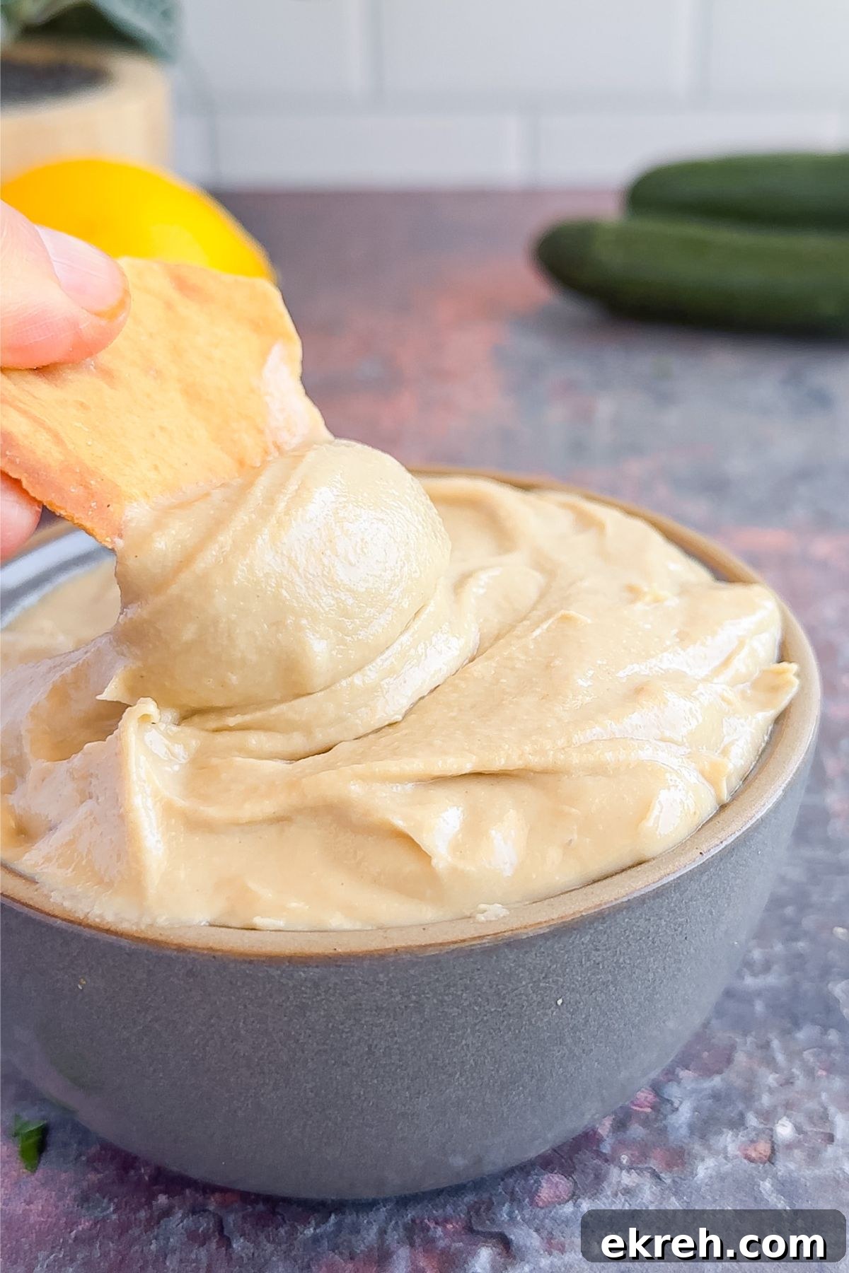 Tahini Sauce Recipe: Creamy Salad Dressing and Dips 8 Dipping a pita chip into tahini sauce.