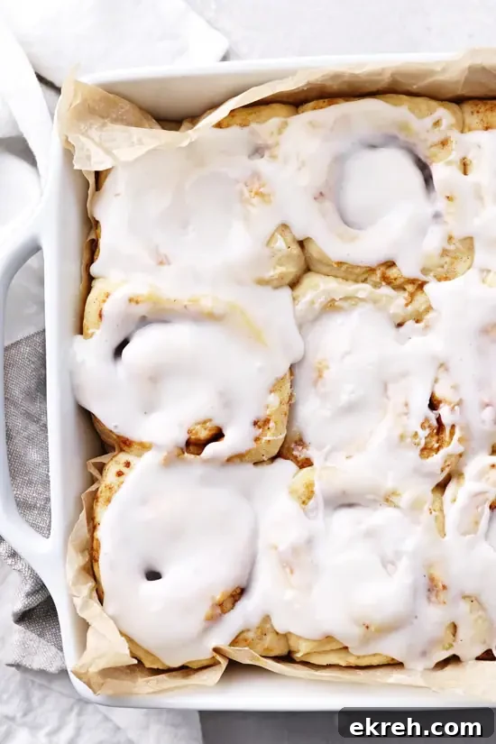 Dairy-Free Cinnamon Rolls Recipe: Soft, Gooey, Fluffy 4 A white baking dish filled with iced Dairy Free Cinnamon Buns.