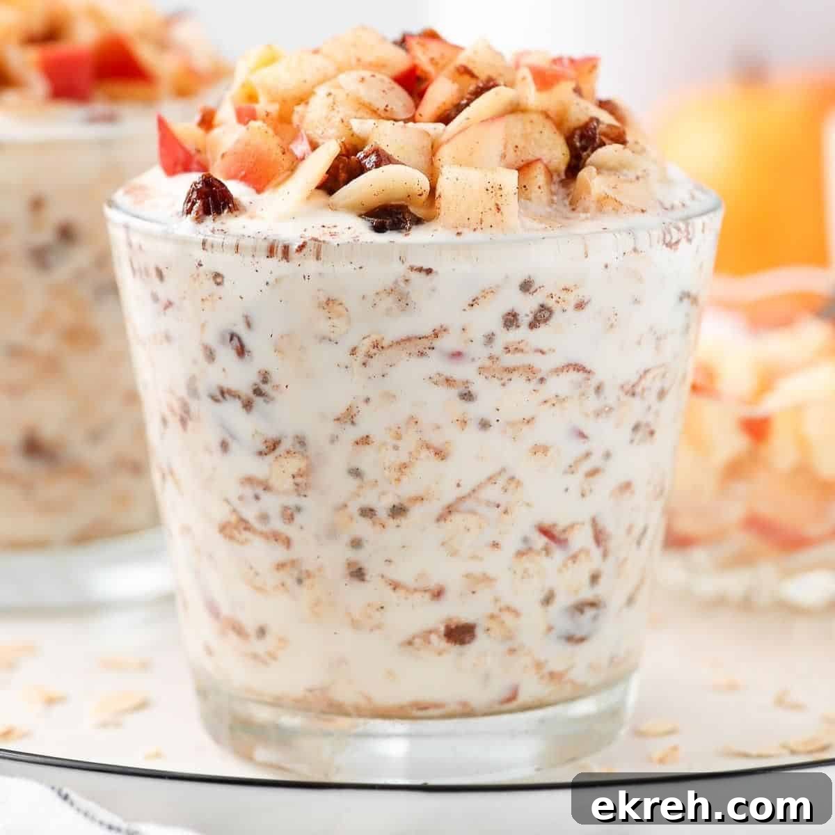 Glass with overnight oats, topped with cubes of apple.