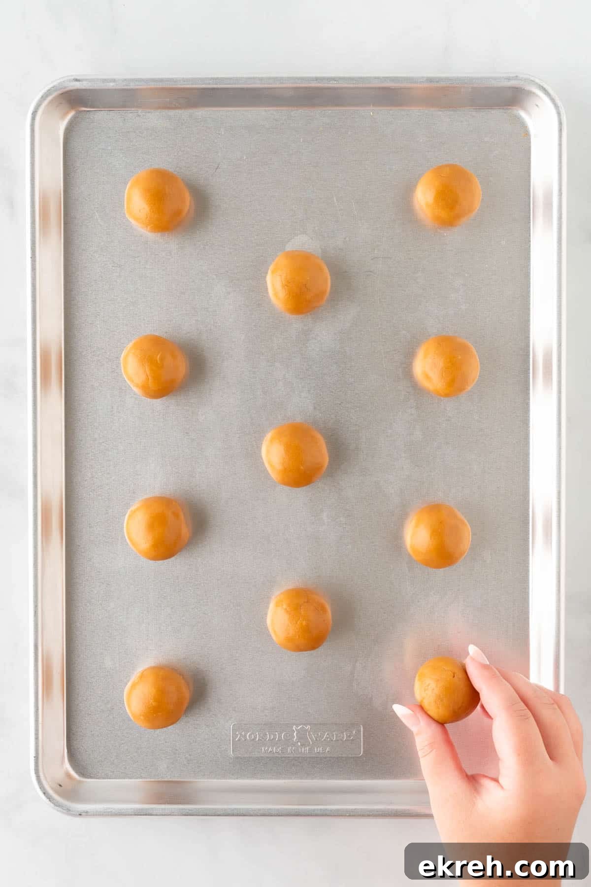 rolled balls of dough on a baking sheet
