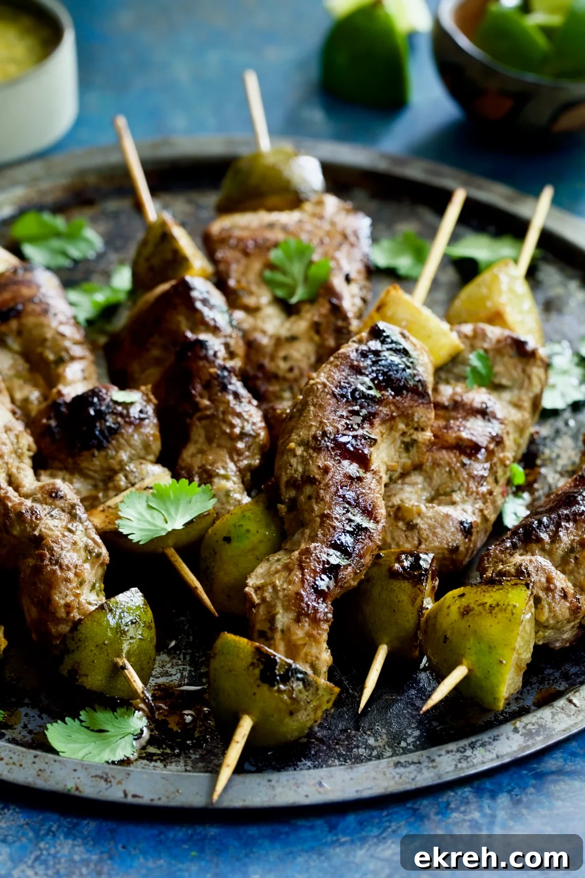 Grilled Citrus Mojo Pork Tenderloin Skewers 13 Mojo-Marinated Pork Skewers on metal tray.