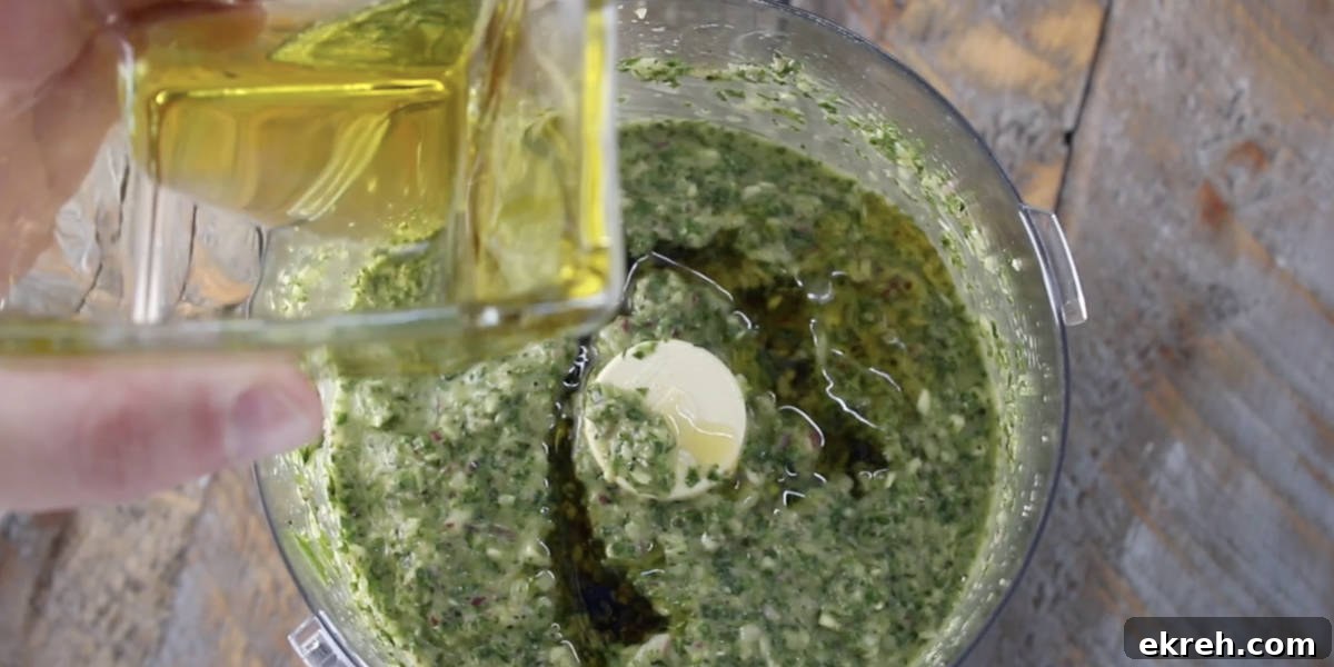 dumping the remainder of the olive oil into the food processor after pulsing the chimichurri