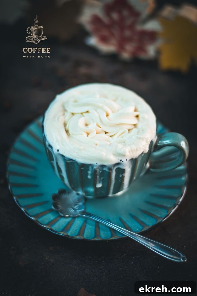 3-Ingredient Maple Whipped Cream Recipe 2 Blue coffee mug with coffee and maple syrup whipped cream topping. A little overflowing.