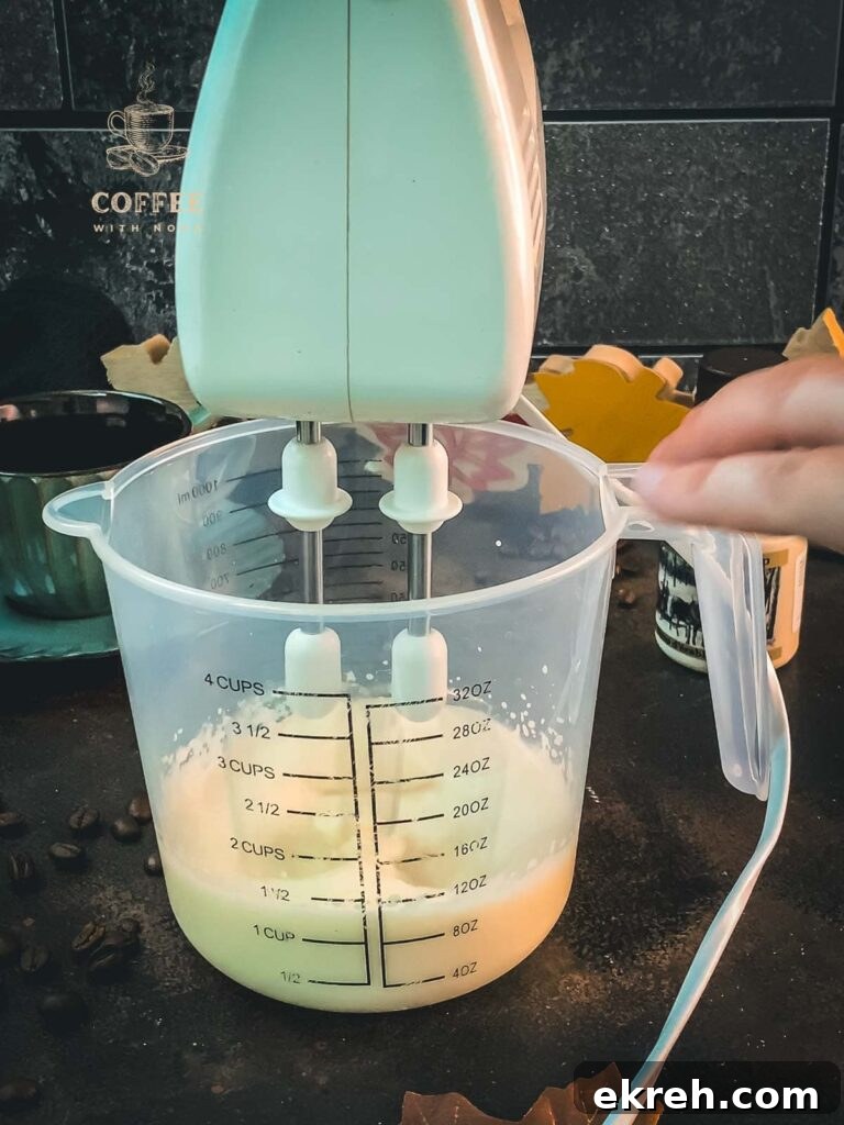 3-Ingredient Maple Whipped Cream Recipe 7 Electric mixer beats heavy cream in measuring cup.
