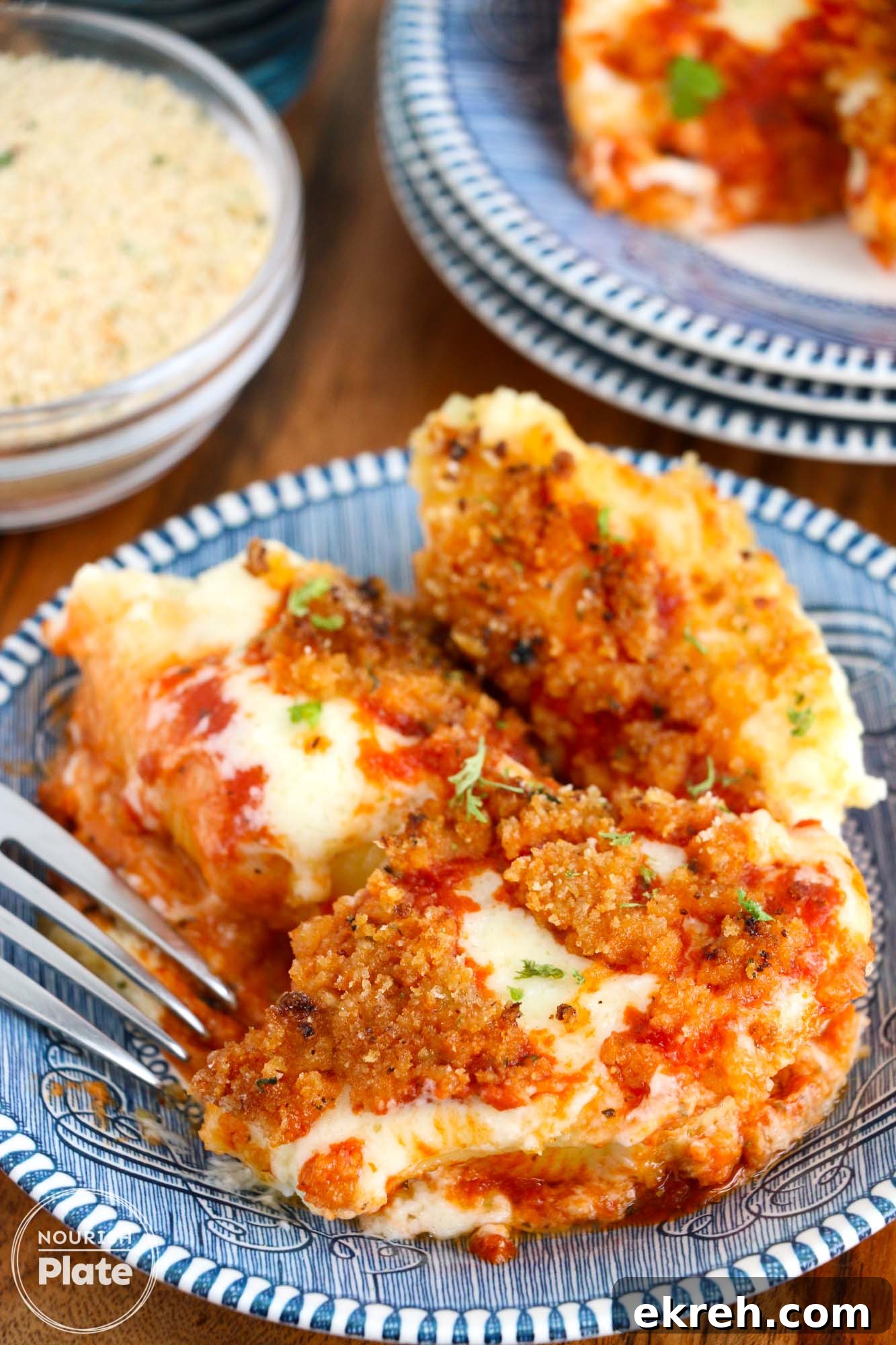 Olive Garden Stuffed Shells Copycat Recipe 2 Olive garden style stuffed shells served on blue plates, and a fork on the side.