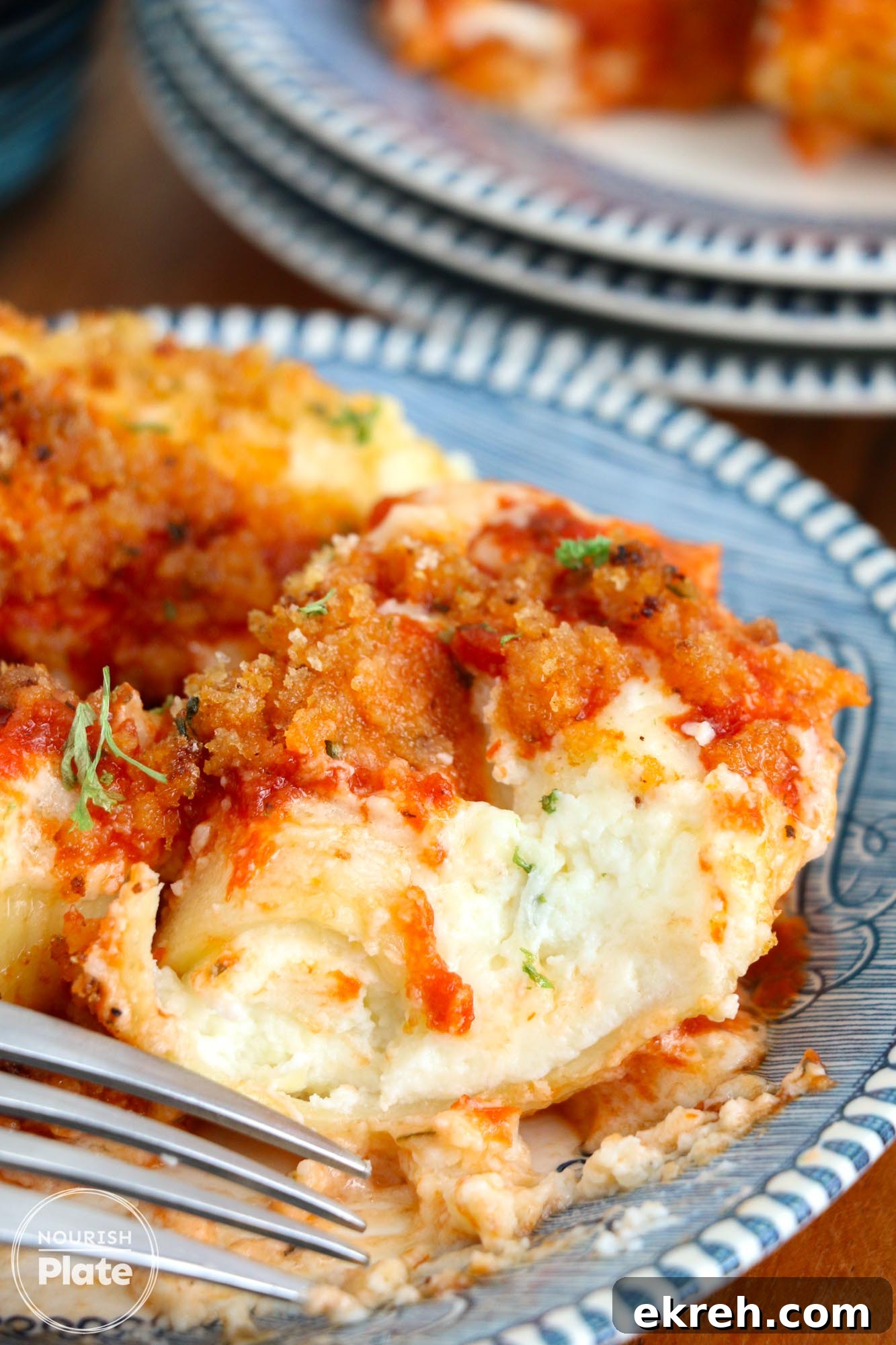 Olive Garden Stuffed Shells Copycat Recipe 13 Showing a bite shot of a jumbo stuffed pasta shell, plated.