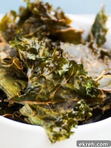 Homemade kale chips in a white bowl.