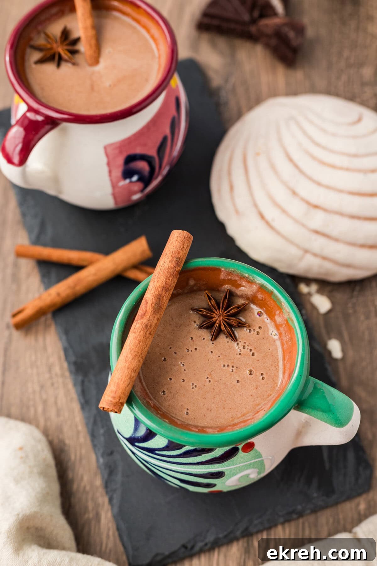 Champurrado Recipe: Authentic Mexican Hot Chocolate 2 Two mugs of Champurrado with a cinnamon stick and star anise resting on top