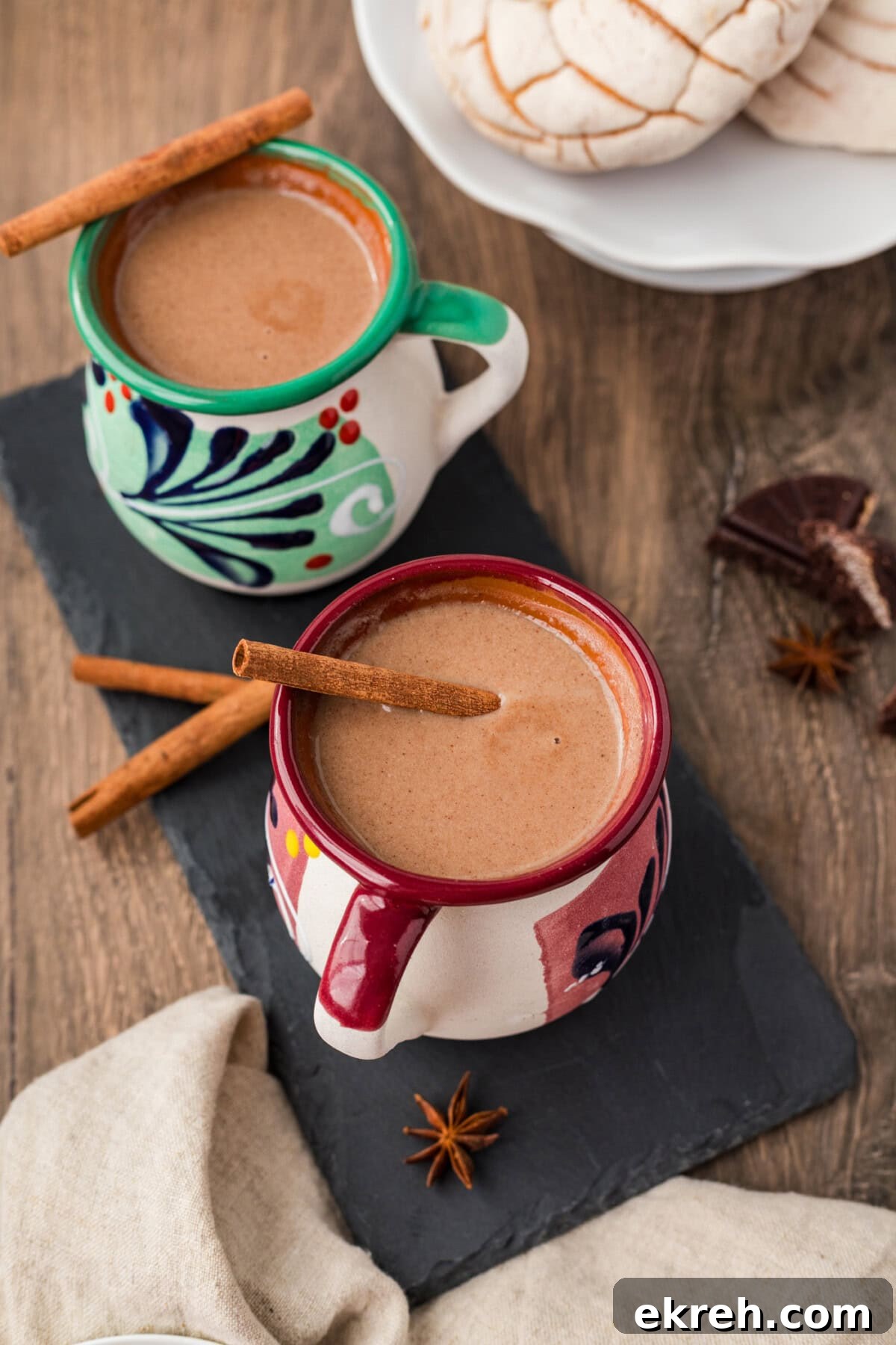 Champurrado Recipe: Authentic Mexican Hot Chocolate 3 Two mugs of Champurrado with a cinnamon stick resting on top