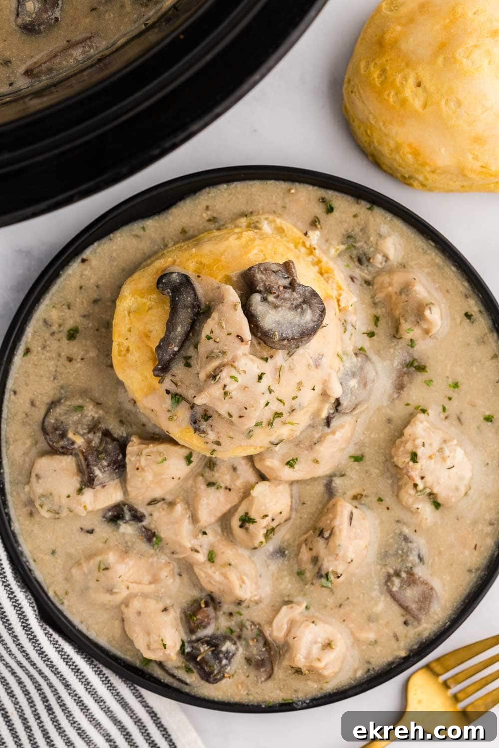 biscuit in Slow Cooker Chicken and Gravy served on plate next to fork