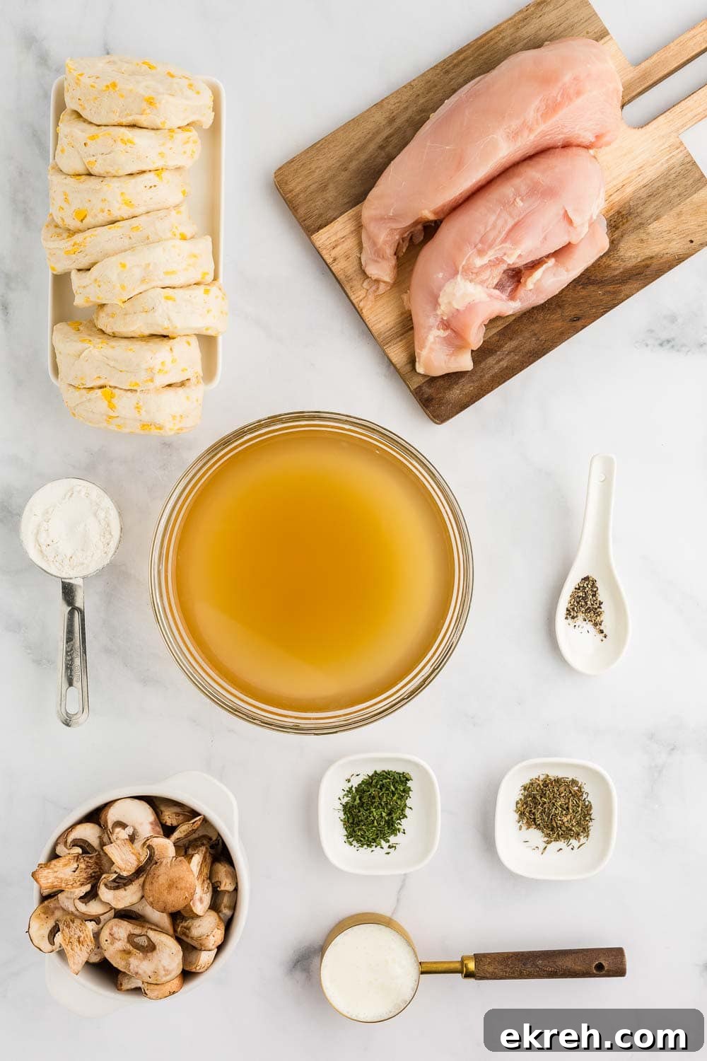 ingredients like mushroom, spices, cream, flour, chicken, and broth all laid out on table