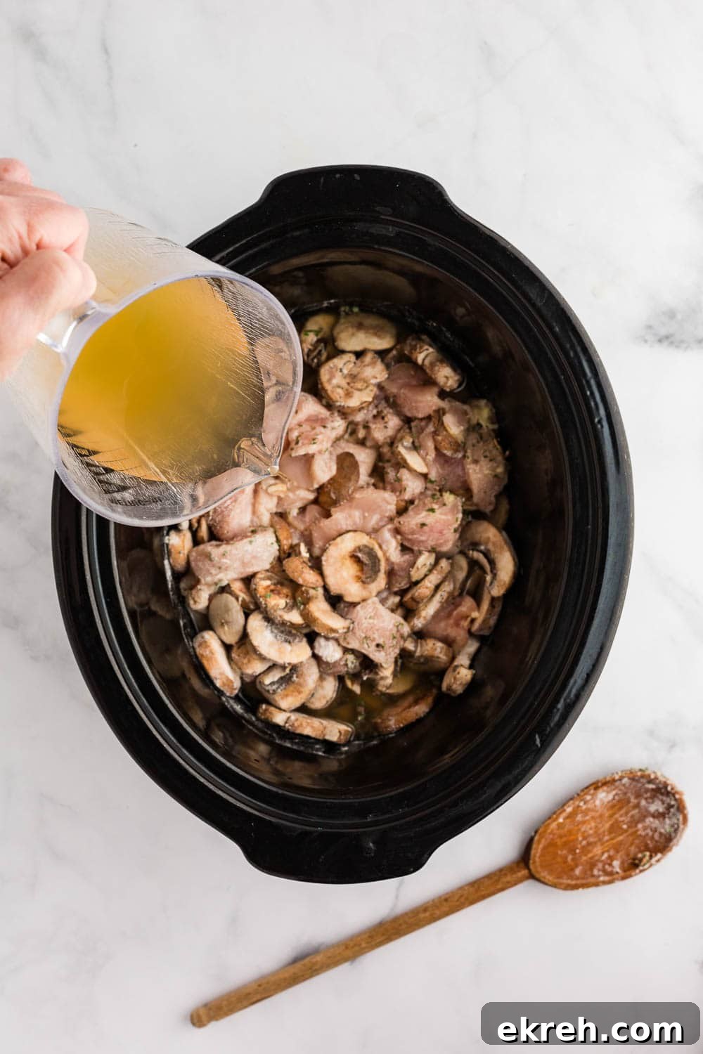 mushroom and broth poured inside slow cooker