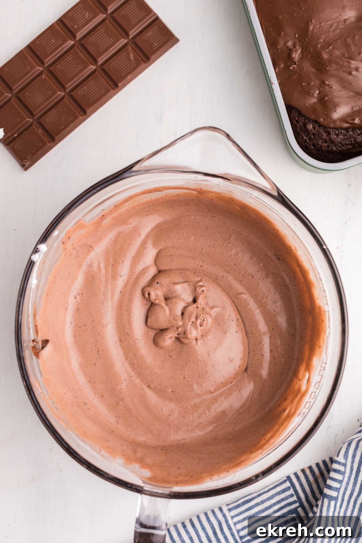 Whipped cream mixed with chocolate pudding mix in a clear glass bowl. 