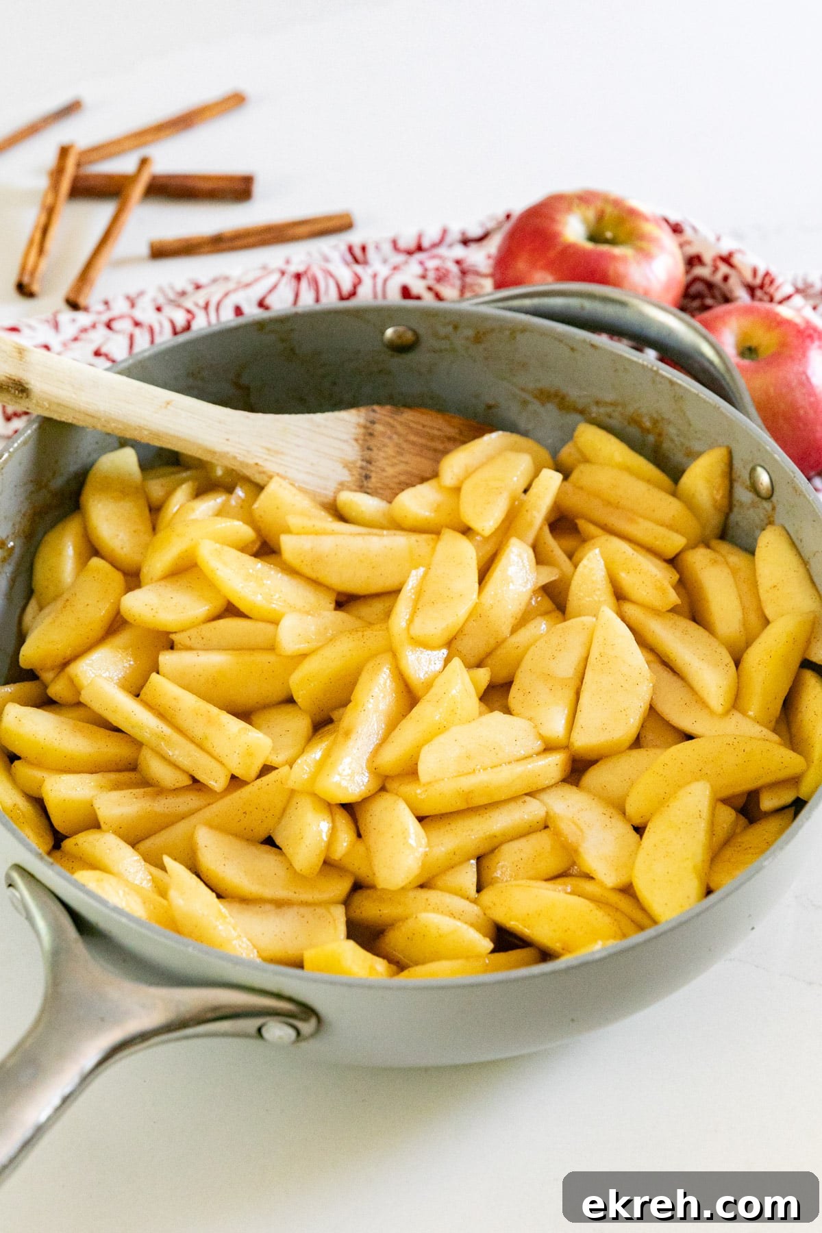 How to Make Apple Pie Filling from Scratch 2 A pan of apple pie filling with a wooden spoon in it.