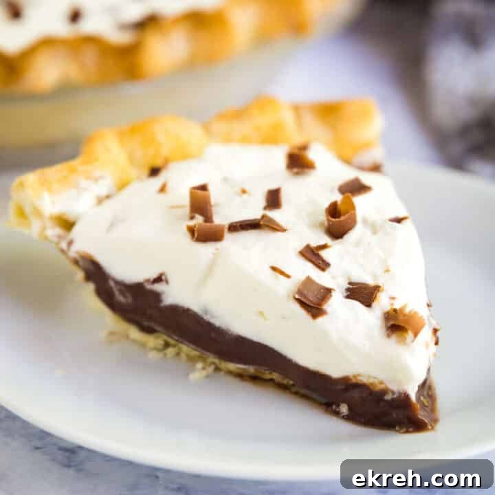 How to Make Apple Pie Filling from Scratch 11 A close up image of a slice of chocolate pudding pie on a white plate with the rest of the pie behind it.