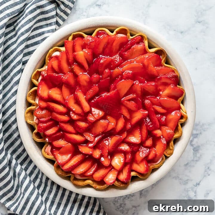 How to Make Apple Pie Filling from Scratch 9 An overhead image of a strawberry cream pie with a striped napkin next to it.