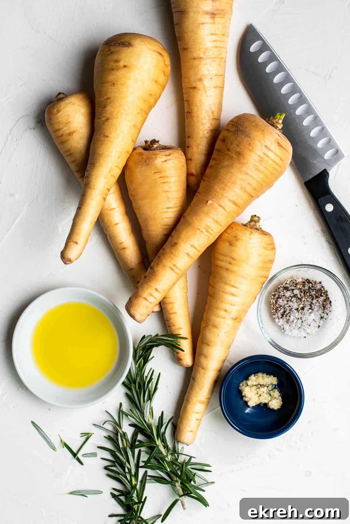 Crispy Oven-Roasted Parsnips with Garlic and Herbs 3 all of the ingredients for roasted parsnips on a white countertop
