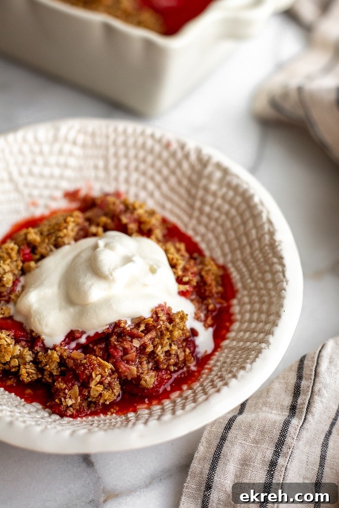 Gluten free strawberry crisp in serving bowl with whipped cream on top