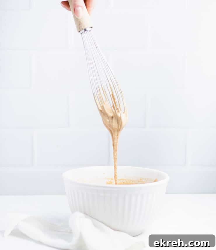 S'mores Donuts Recipe: Chocolate, Marshmallow and Graham 3 batter dripping off a whisk to show consistency