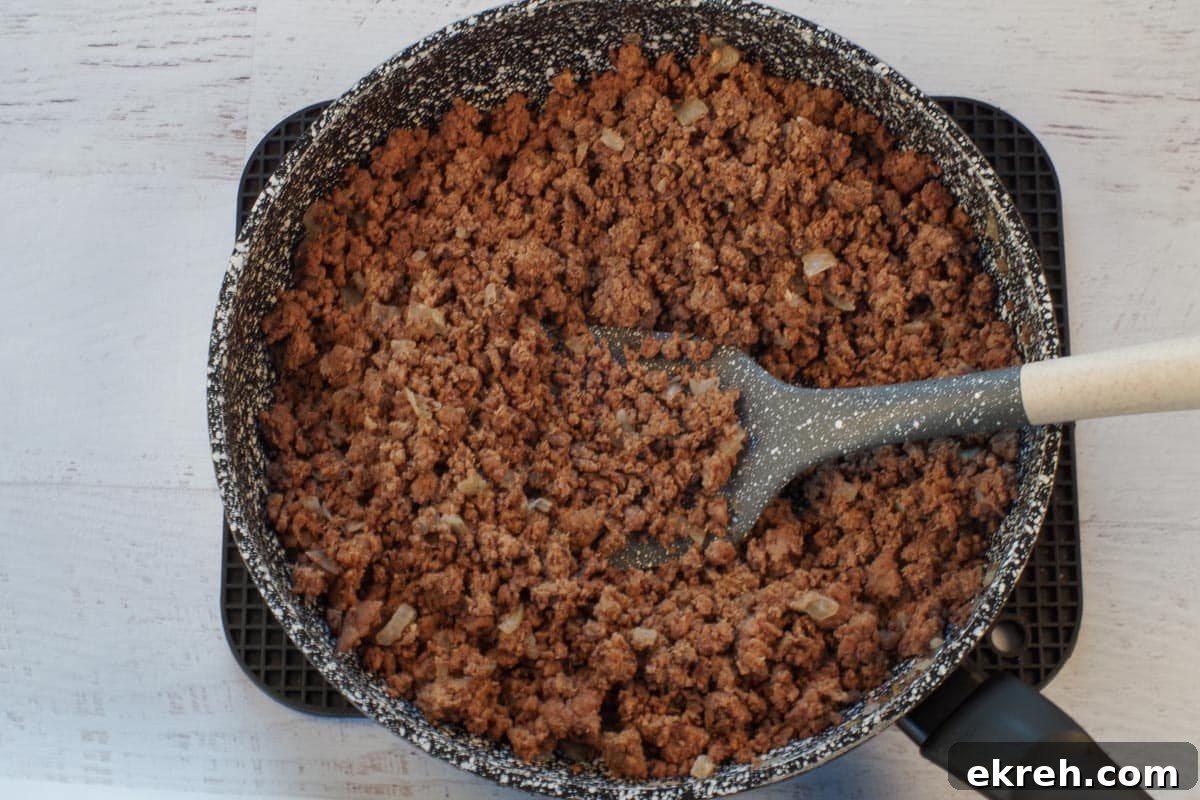 cooked ground beef in frying pan with spatula