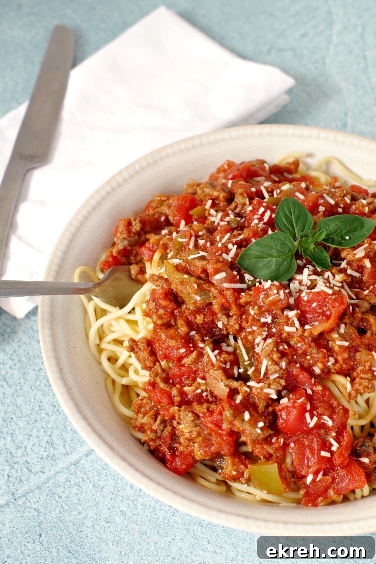 Spaghetti and meat sauce in a beige bowl
