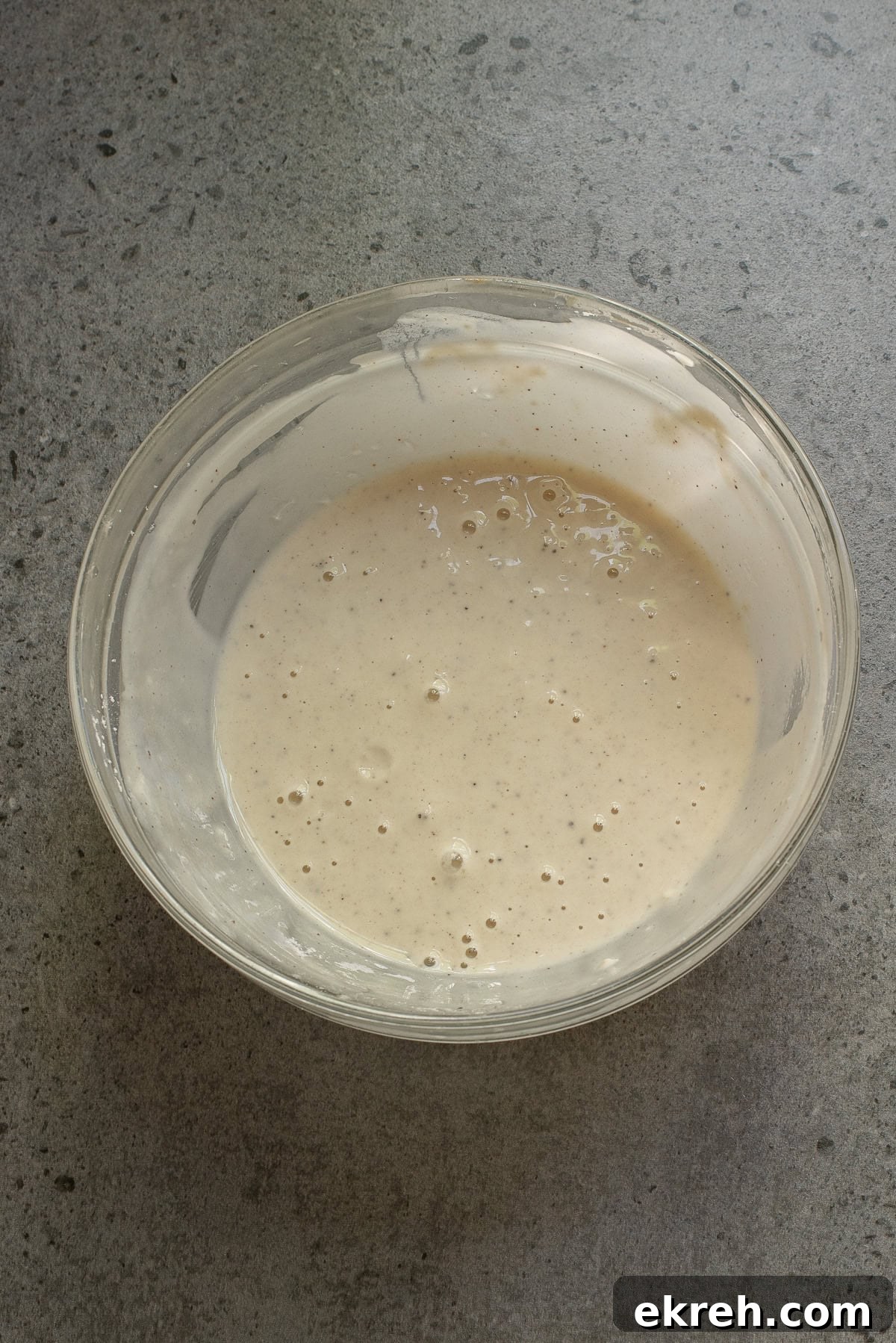 An overhead image of whisking together flour, cornstarch, garlic powder, salt, and pepper.