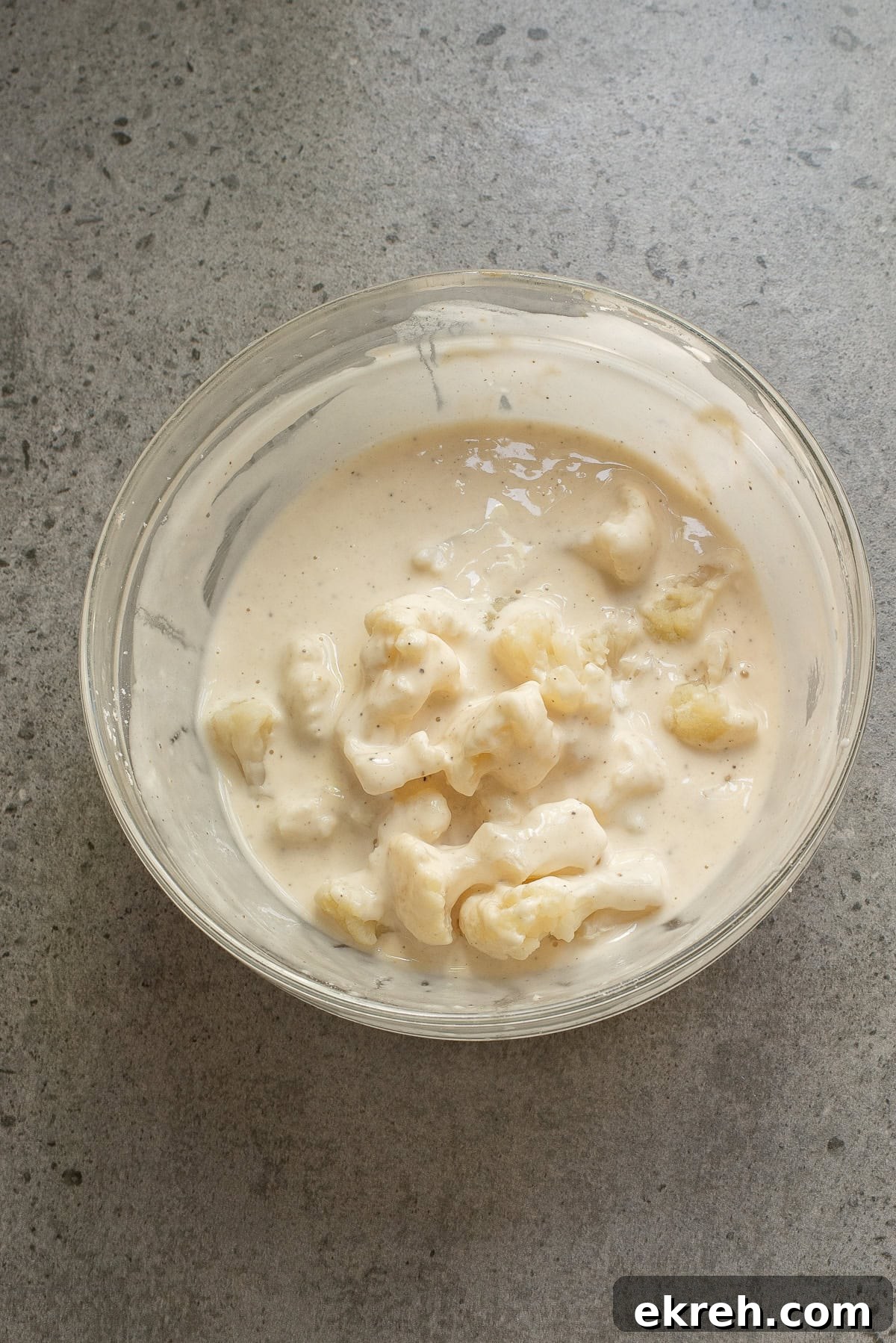 An overhead image of dipping cauliflower in a bowl.
