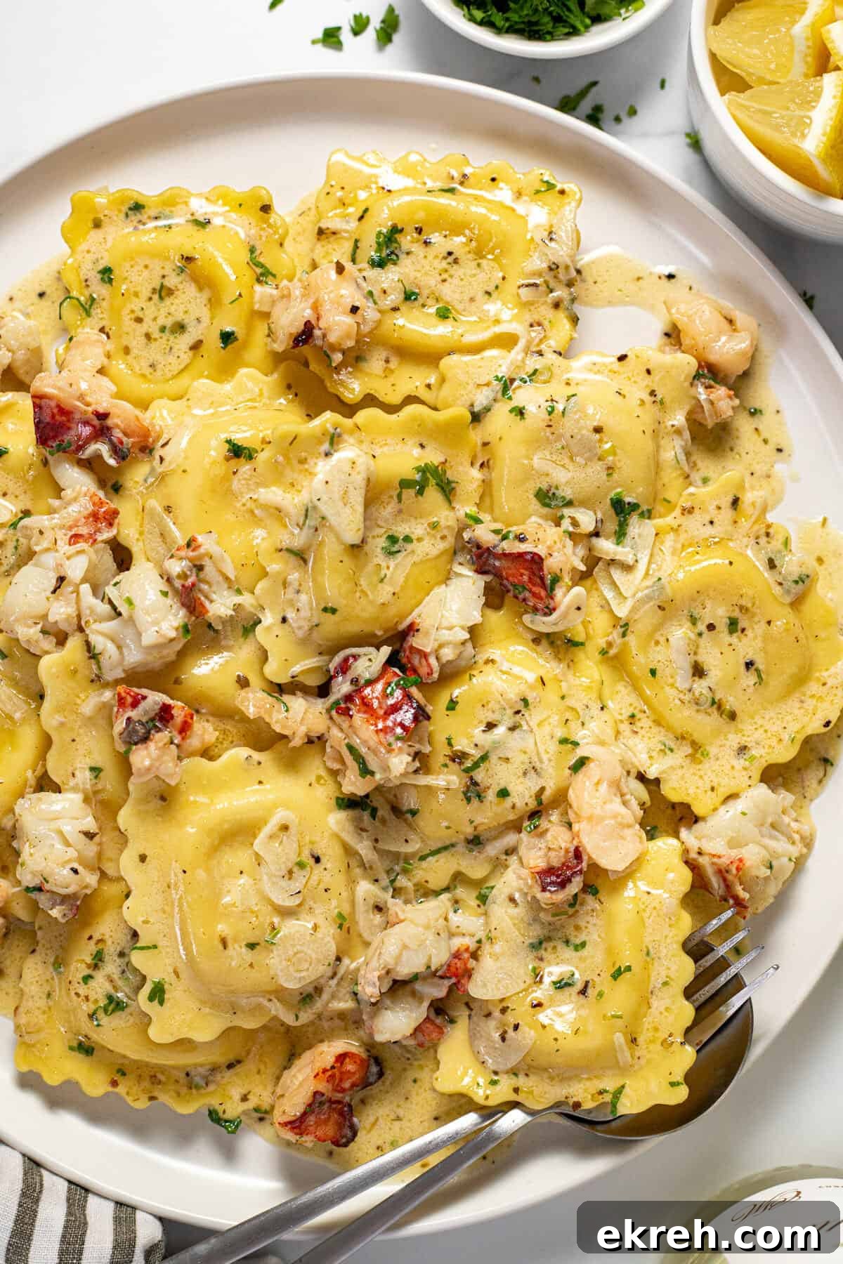 White plate filled with cheese ravioli and a creamy lobster ravioli sauce